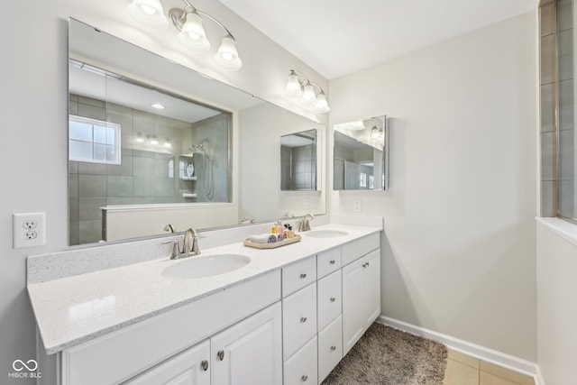 bathroom with double vanity, tile patterned flooring, baseboards, and a sink