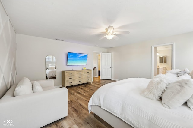 bedroom featuring ceiling fan, connected bathroom, visible vents, baseboards, and light wood-style floors