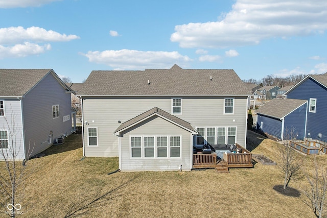 back of property with a deck, an outdoor hangout area, a lawn, and roof with shingles