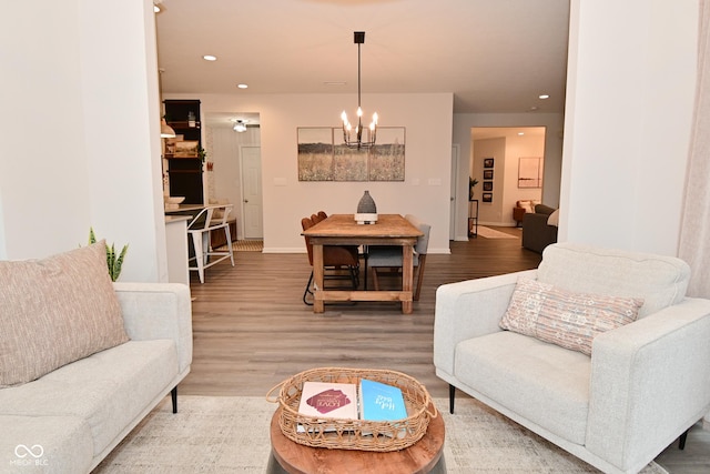 living area featuring baseboards, a chandelier, wood finished floors, and recessed lighting