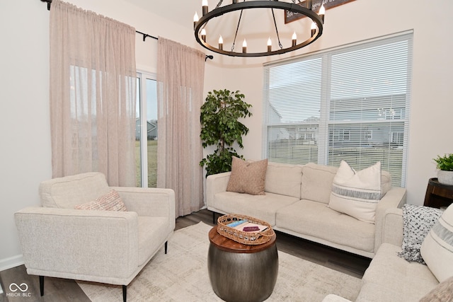 living area featuring wood finished floors, a wealth of natural light, and a notable chandelier