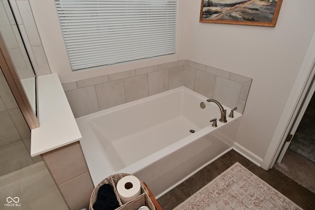 full bath with a garden tub, baseboards, and tile patterned floors