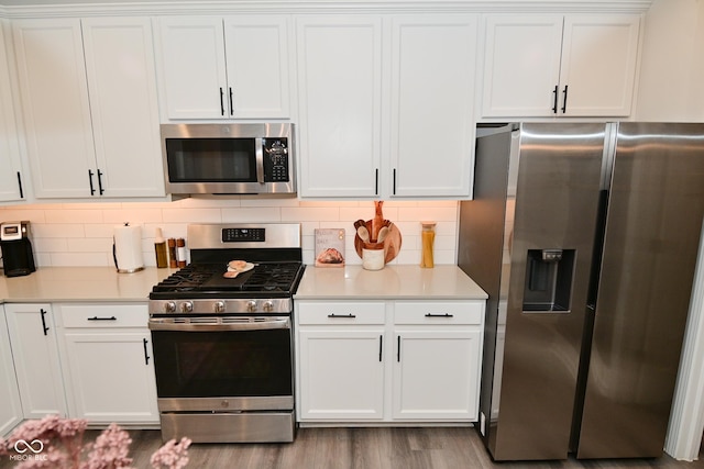 kitchen with appliances with stainless steel finishes, light countertops, decorative backsplash, and white cabinetry