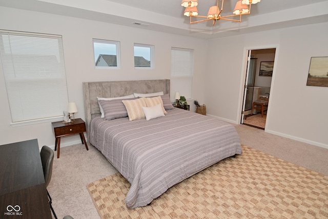 carpeted bedroom with baseboards, a raised ceiling, visible vents, and an inviting chandelier