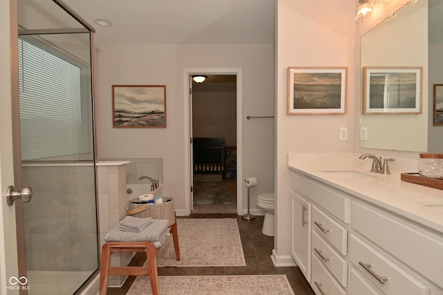 full bathroom featuring tile patterned flooring, toilet, a sink, a shower stall, and double vanity