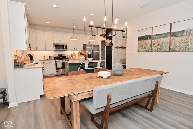 dining space featuring light wood-style flooring, visible vents, baseboards, and recessed lighting