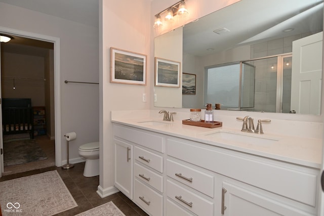 full bathroom featuring toilet, a stall shower, a sink, and tile patterned floors