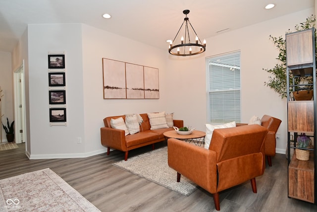 living room featuring recessed lighting, a notable chandelier, baseboards, and wood finished floors