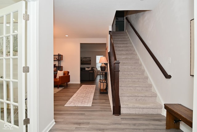 interior space with baseboards, stairway, wood finished floors, and recessed lighting