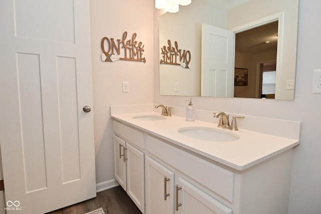 bathroom featuring wood finished floors, a sink, and double vanity