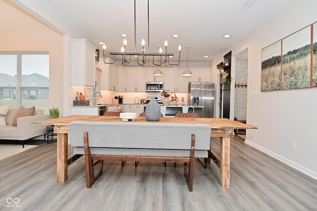 dining area with light wood finished floors, baseboards, and recessed lighting