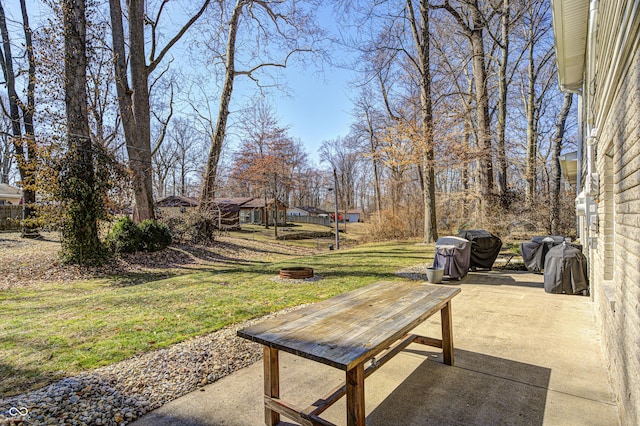 view of community with a patio area, an outdoor fire pit, and a yard