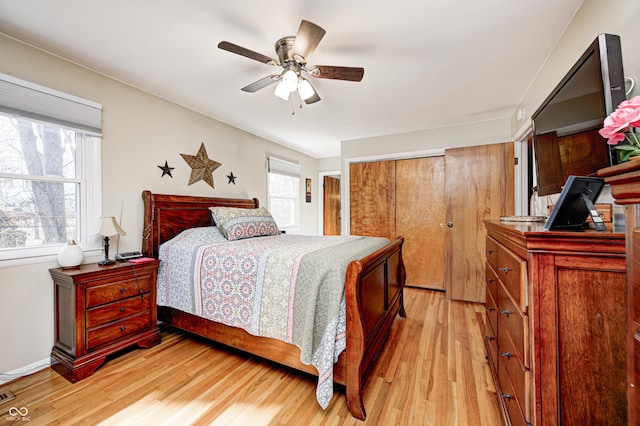 bedroom with light wood-style flooring, visible vents, a ceiling fan, and a closet