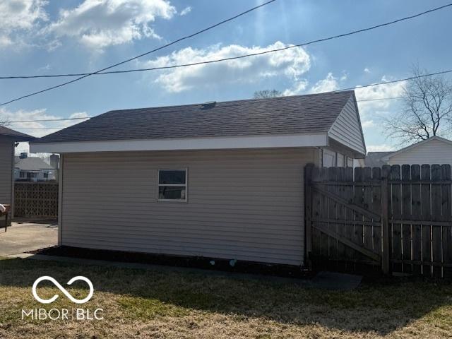 view of property exterior with fence and roof with shingles