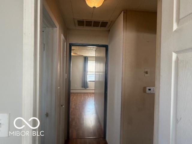 hall with visible vents and wood finished floors