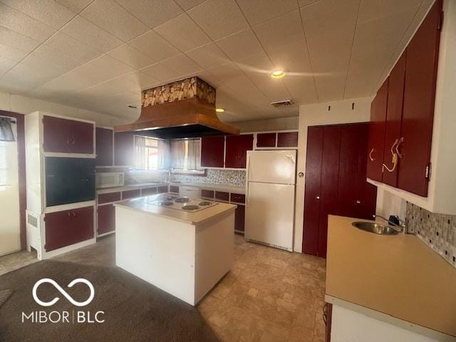 kitchen featuring white appliances, visible vents, a sink, light countertops, and backsplash