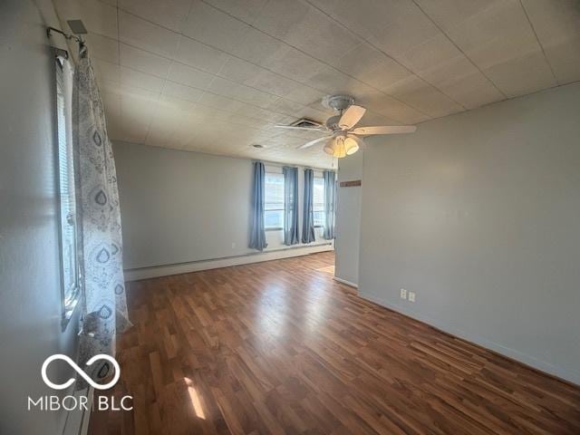 unfurnished room featuring a ceiling fan, wood finished floors, and baseboards