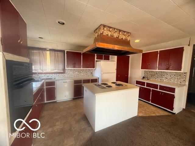 kitchen featuring a sink, white appliances, tasteful backsplash, and a kitchen island