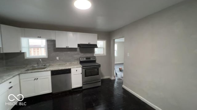 kitchen with appliances with stainless steel finishes, a sink, white cabinetry, and under cabinet range hood