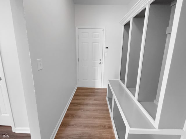 hallway featuring wood finished floors and baseboards