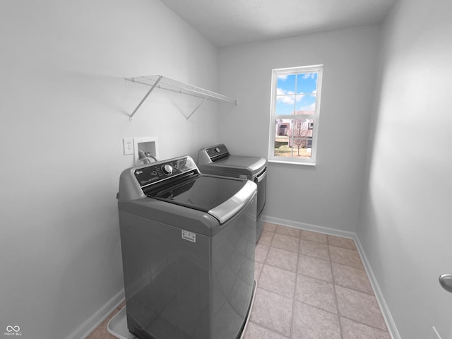 washroom with laundry area, baseboards, and separate washer and dryer