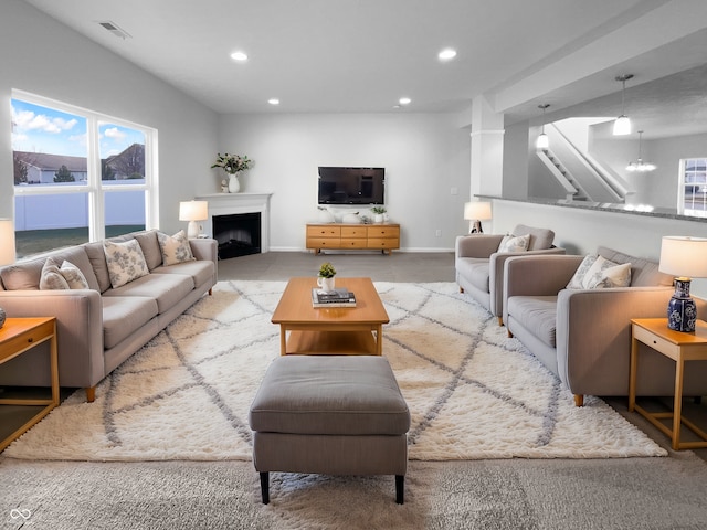 living area with recessed lighting, visible vents, a fireplace, and baseboards