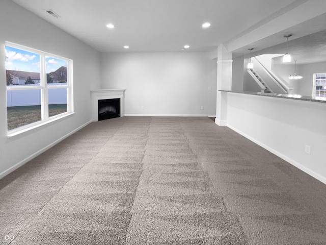 unfurnished living room featuring visible vents, baseboards, carpet, a fireplace, and recessed lighting