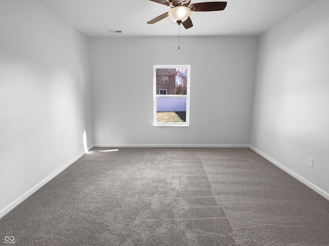 empty room with carpet, visible vents, ceiling fan, and baseboards