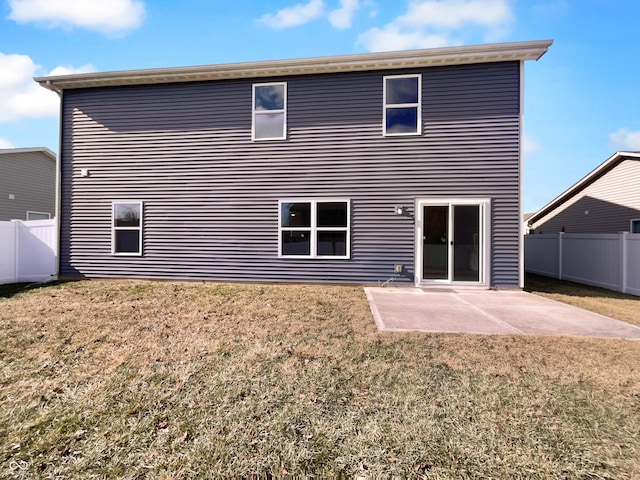 rear view of house with a fenced backyard, a lawn, and a patio