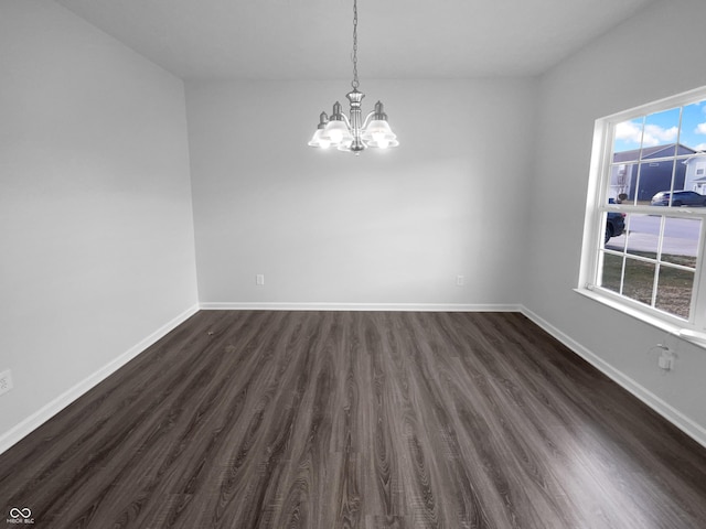 empty room with dark wood-type flooring, baseboards, and an inviting chandelier