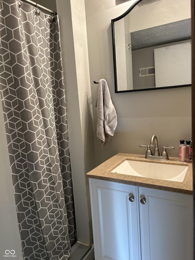 full bath featuring a shower with curtain, visible vents, and vanity