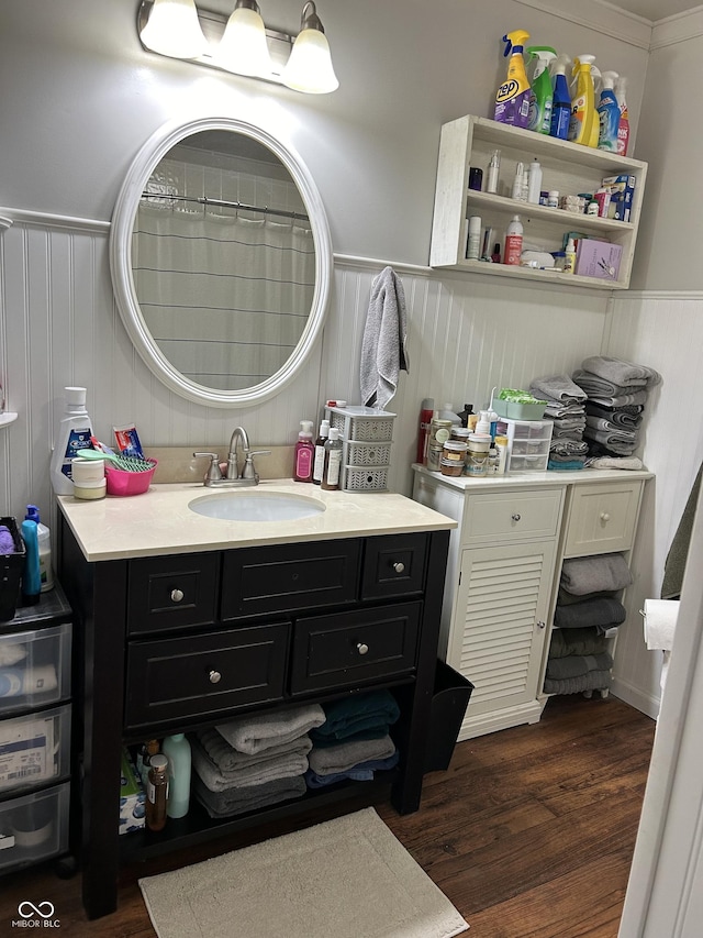 full bathroom featuring a wainscoted wall and wood finished floors