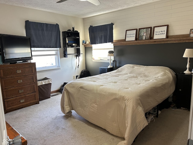 carpeted bedroom featuring ceiling fan, a textured ceiling, and baseboards
