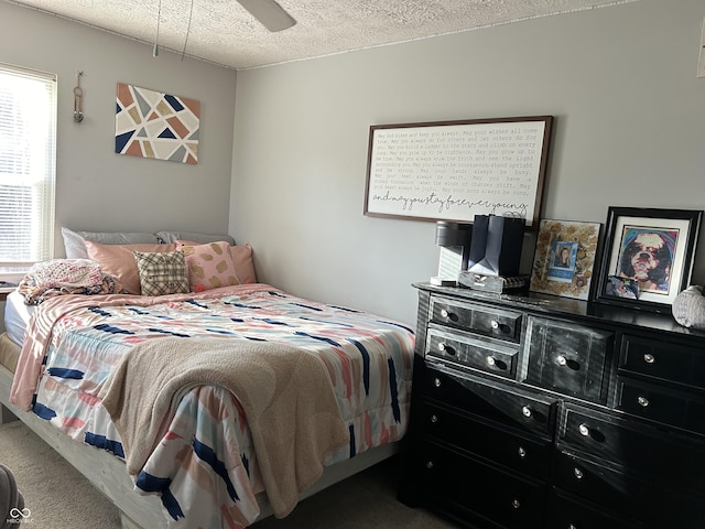 bedroom featuring a textured ceiling, carpet floors, and ceiling fan