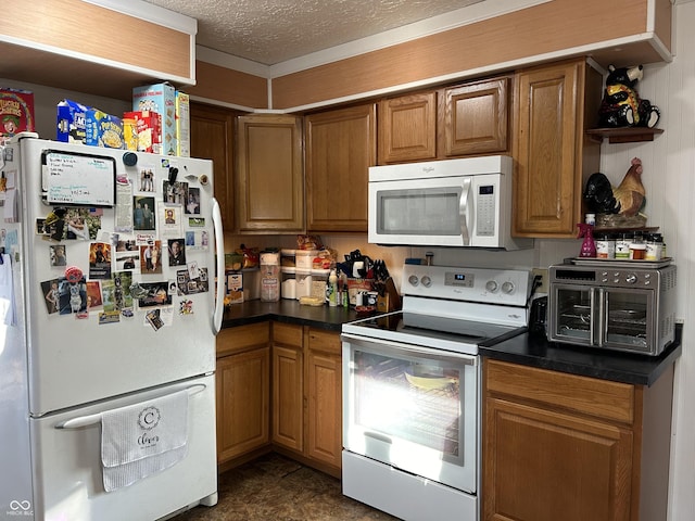kitchen with a textured ceiling, white appliances, brown cabinetry, and dark countertops