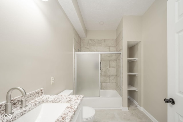 full bathroom with a textured ceiling, toilet, bath / shower combo with glass door, vanity, and baseboards