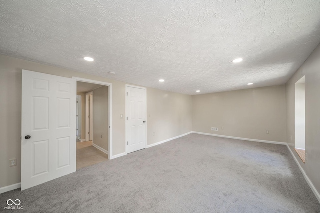 basement with carpet floors, a textured ceiling, and baseboards