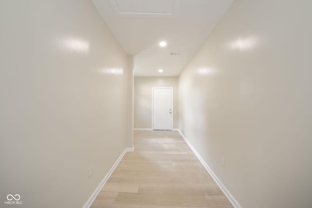 hall with light wood-style floors, recessed lighting, visible vents, and baseboards