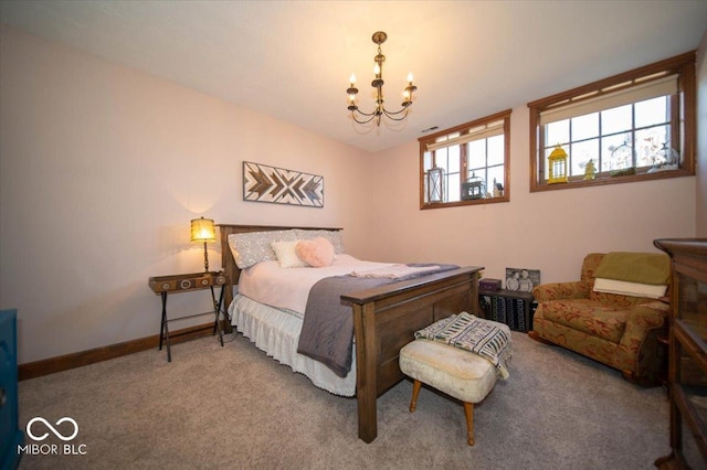 carpeted bedroom with a chandelier and baseboards