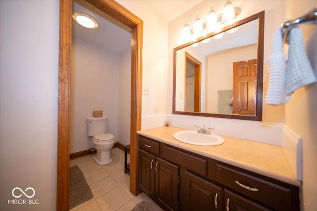 bathroom featuring toilet, vanity, baseboards, and tile patterned floors