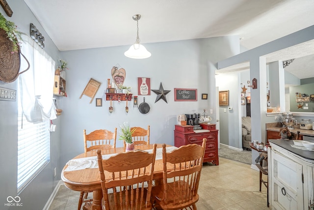 dining room with baseboards and vaulted ceiling