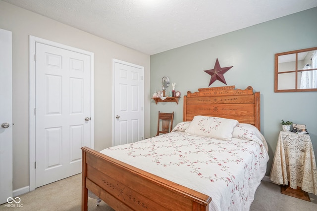 bedroom with light carpet and a textured ceiling