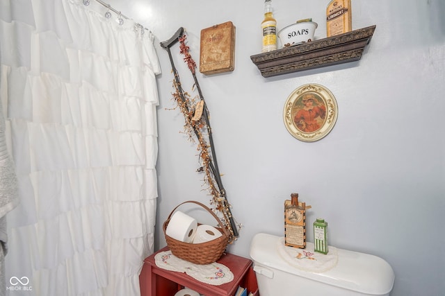 room details featuring a shower with shower curtain and toilet