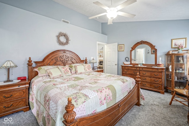 carpeted bedroom featuring visible vents, lofted ceiling, and ceiling fan