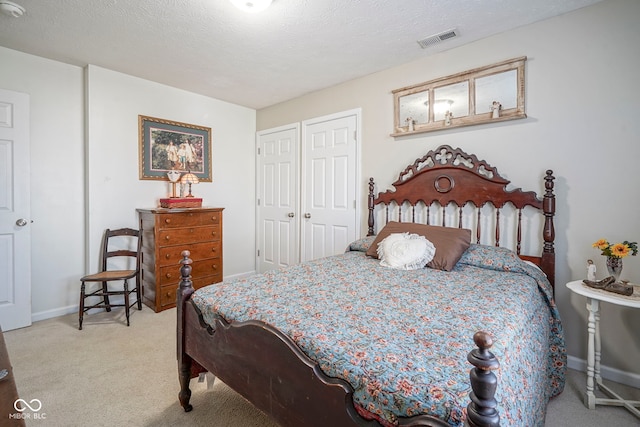 carpeted bedroom featuring visible vents, a textured ceiling, and baseboards