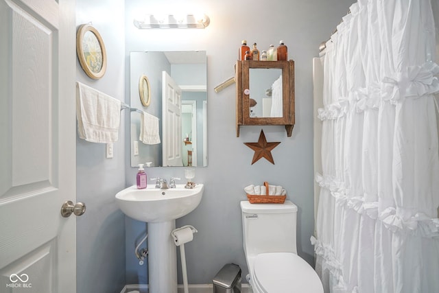 full bathroom featuring a shower with shower curtain and toilet