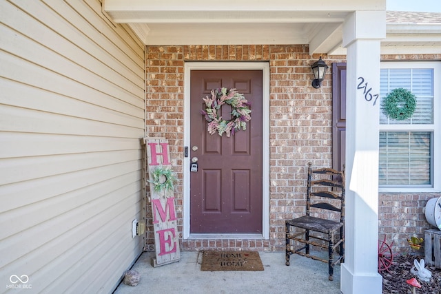 property entrance featuring brick siding