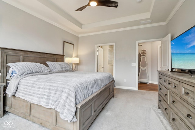 bedroom with a raised ceiling, visible vents, light carpet, ceiling fan, and baseboards