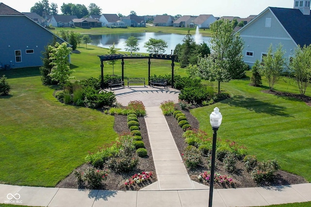 surrounding community with a water view, a residential view, and a lawn