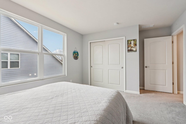 unfurnished bedroom featuring a closet, carpet flooring, visible vents, and baseboards